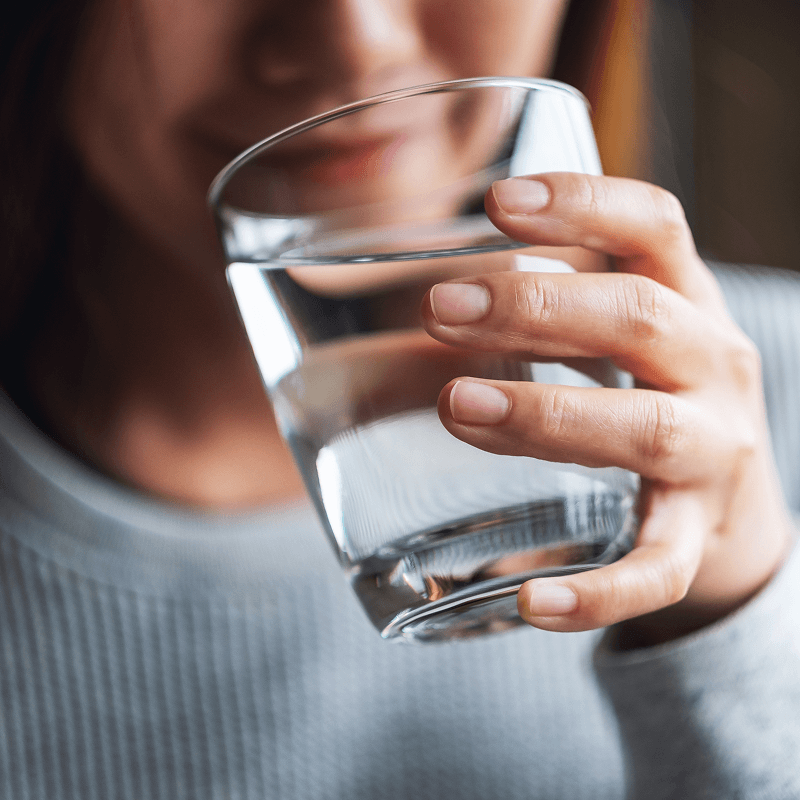 Person drinkning from a glass of water